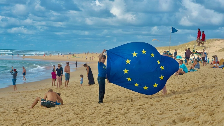 Kinder am Strand mit EU-Fahne